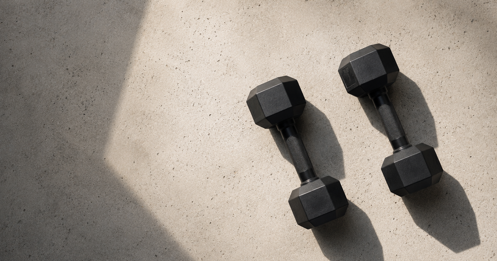 Hex dumbbells on concrete floor with side light